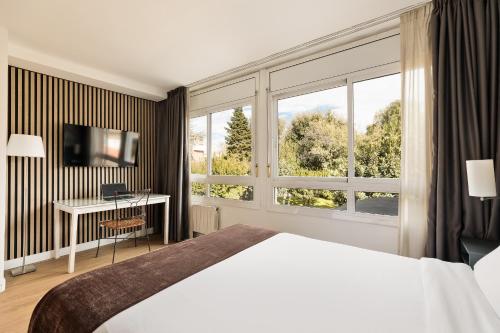 a hotel room with a bed and a large window at PARK SEDO Aparthotel in Rubí
