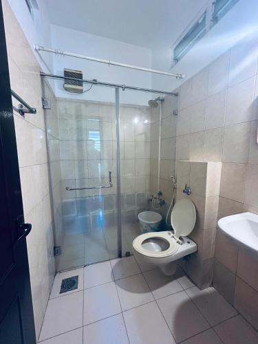 a bathroom with a shower and a toilet and a sink at HOTEL IHAM PARADISE - Near Mangalore Central Railway Station - Pets Not Allowed in Mangalore