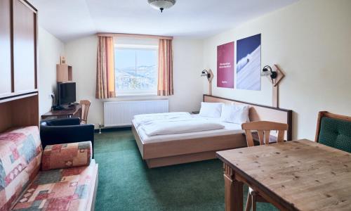 a hotel room with a bed and a table at Hotel Kirchboden by Alpeffect Hotels in Wagrain