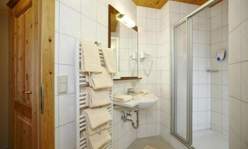 a white bathroom with a sink and a mirror at Hotel Kirchboden by Alpeffect Hotels in Wagrain