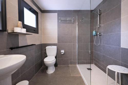 ein Badezimmer mit Toilette und Glasdusche in der Unterkunft Adia Hotel Cunit Playa in Cunit