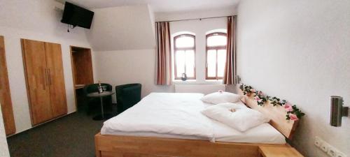 a bedroom with a bed with white sheets and pillows at BBZ Burg Weißensee in Weißensee