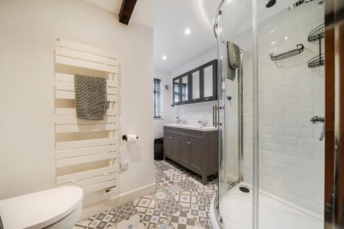 a bathroom with a shower and a toilet and a sink at Eagle's Nest in Worplesdon