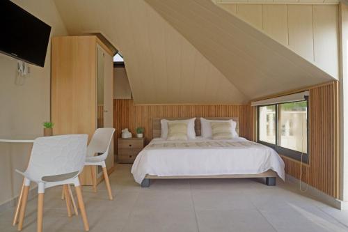 a bedroom with a bed and a table and chairs at Villa Olivera Hotel in Tḩūm at Taḩtā