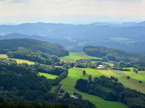 - une vue sur une vallée avec des champs et des arbres verdoyants dans l'établissement Former farmhouse with sunbathing lawn, à Zenting