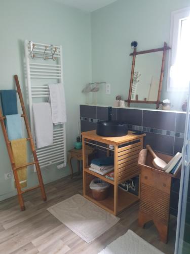 a bathroom with a sink and a wooden table at Chambre d'hôtes Le Luquet in Chazelles