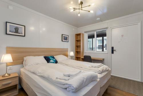 ein Schlafzimmer mit einem großen Bett mit weißer Bettwäsche in der Unterkunft Hotel Boli Keflavik in Njarðvík