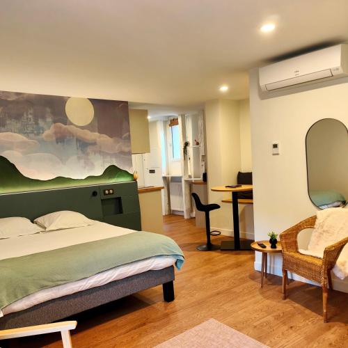 a bedroom with a bed and a desk and a chair at Les appart'hotels de la fontaine in Autoire
