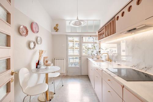 a kitchen with white counters and a table and chairs at AMAZING DUPLEX - Mid Century Experience & PARKING in Porto