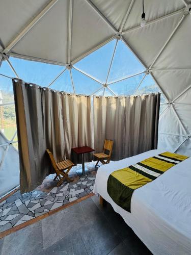 a bedroom in a tent with a bed and a table at Glamping Mascota in La Providencia