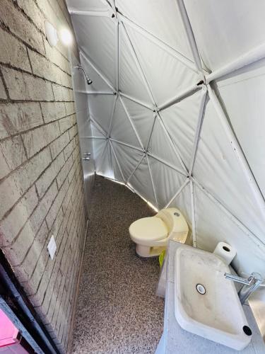 a small bathroom with a toilet and a sink at Glamping Mascota in La Providencia