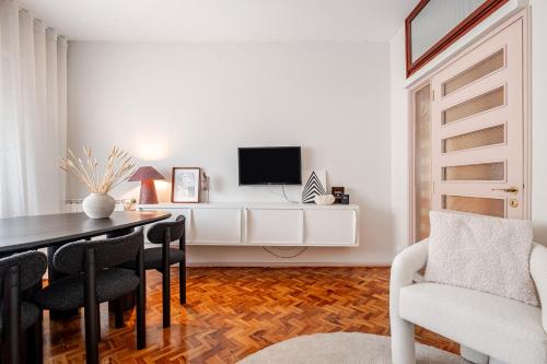 a living room with a dining room table and a tv at AMAZING DUPLEX - Mid Century Experience & PARKING in Porto