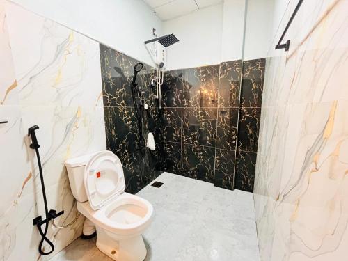 a bathroom with a toilet and a shower at Coral Bay Villa in Pottuvil