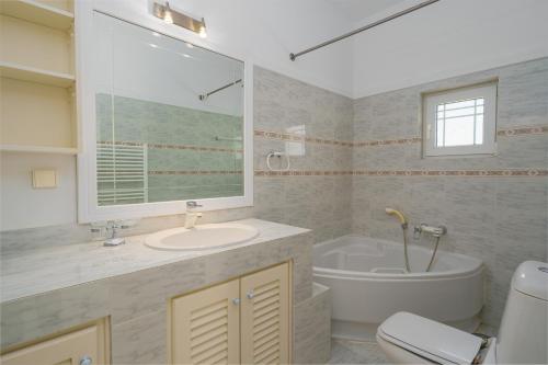 a bathroom with a tub and a sink and a toilet at The Marina View in Lavrio