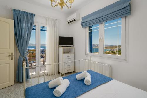 a bedroom with a bed and a large window at The Marina View in Lavrio