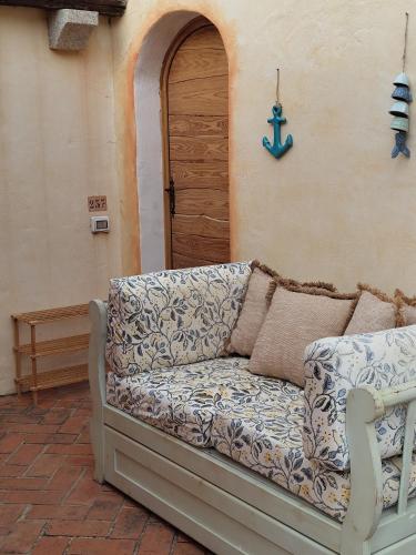 a couch sitting on a patio in front of a door at Appartamento Baia Pitrizza vista mare in Liscia di Vacca