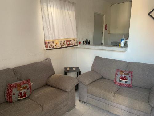 a living room with two couches and a mirror at Casa acogedora en Chetumal in Chetumal