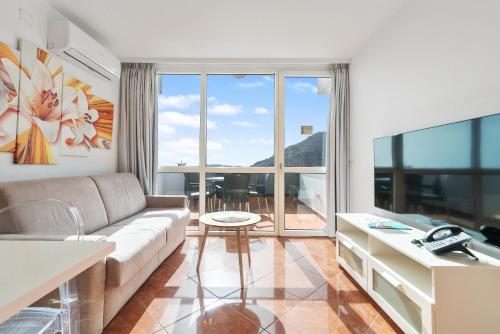 a living room with a couch and a large window at Mariposa del Sol in Patalavaca