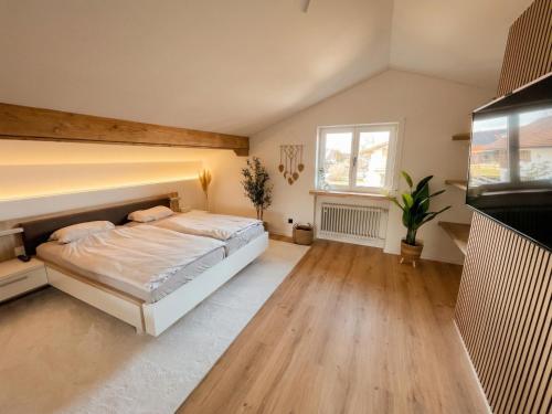a large bedroom with a bed and a window at Scandinavian Alpine Lodge nahe Tegernsee - stilvoll & ruhig in Reichersbeuern