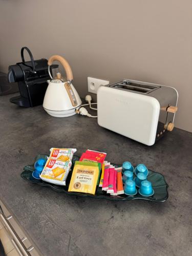 a tray with food and a toaster on a counter at Logement proche Aéroport Nantes in Saint-Aignan-Grand-Lieu