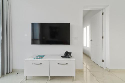 a white room with a tv on a white wall at Mariposa del Sol in Patalavaca