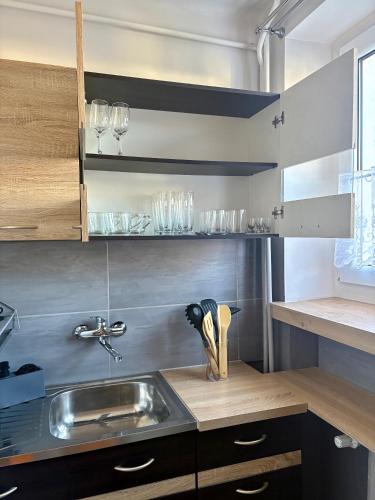 a kitchen with a sink and some glasses on shelves at Przy Zamenhofa in Nowa Sól