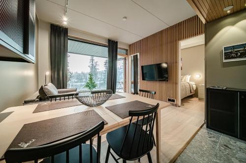 a living room with a table and chairs and a couch at Gielas Joiku Chalet - Ski-in Ski-out - Mountain View - incl 2 ski passes in Kittilä
