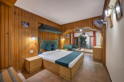 a bedroom with a bed in a room with wooden walls at Brightland Hotel near Mall Road - Stags entry not allowed in Shimla