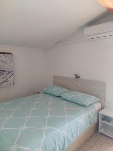 a bedroom with a bed with a blue comforter at VisForYou Apartments in Vis