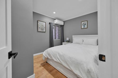 ein Schlafzimmer mit einem weißen Bett und einem Fenster in der Unterkunft Airport Subway Condo in Boston