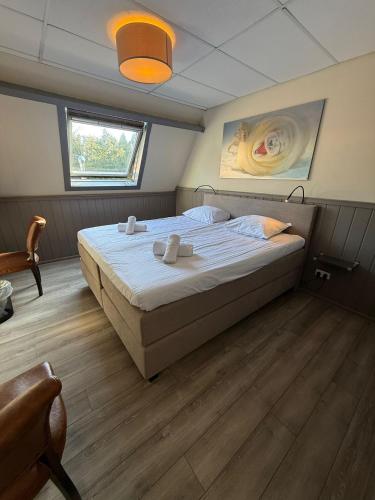 a bedroom with a large bed in a room at Hotel Waddengenot in Pieterburen