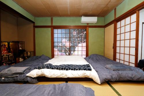 a bedroom with two beds in front of a window at Free Rental Car Villa in Beppu