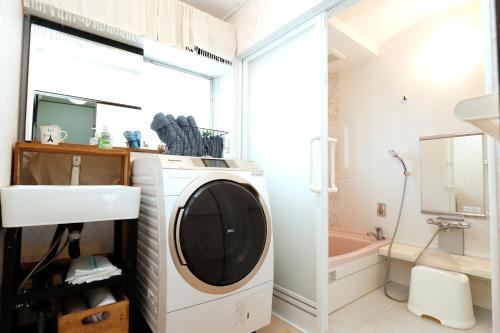 a bathroom with a washing machine and a sink at Free Rental Car Villa in Beppu