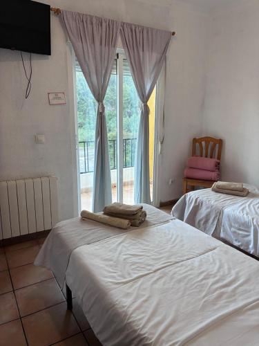 two beds sitting in a room with a window at Hotel Move Espadan in Azuébar