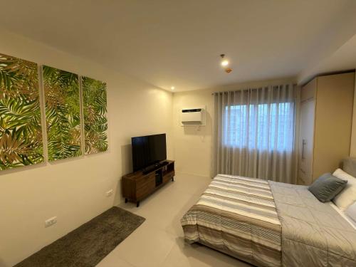 a bedroom with a bed and a flat screen tv at Matina enclaves condo studio type 6thfloor in Davao City