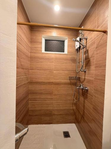 a bathroom with a shower with wooden walls at Matina enclaves condo studio type 6thfloor in Davao City