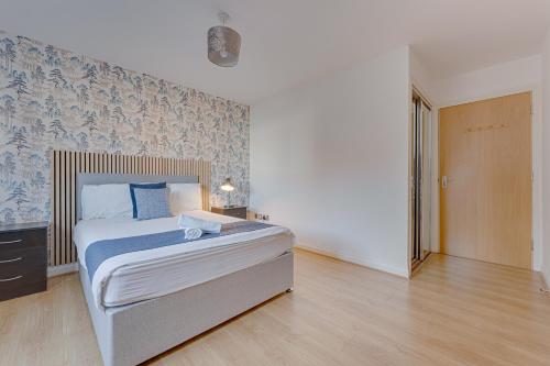 a bedroom with a bed with a blue and white wall at The OVO Hydro Penthouse With Free Parking in Glasgow