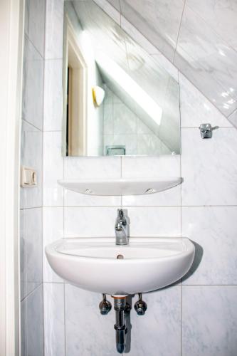 a white sink in a bathroom with a mirror at Strandstr 4b "Likedeeler 2" in Zingst