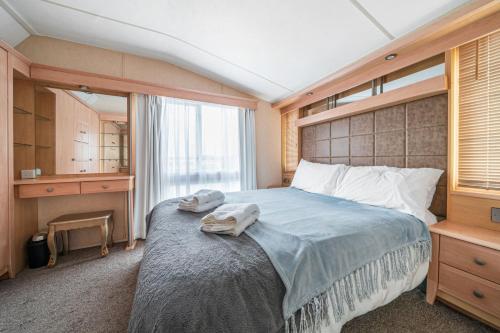 a bedroom with a large bed with towels on it at Washington Lodge in Heacham