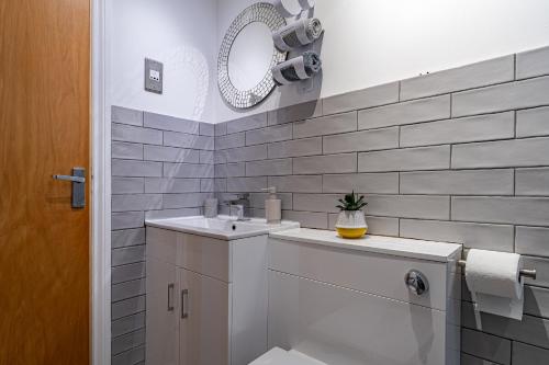a white bathroom with a sink and a mirror at The OVO Hydro Penthouse With Free Parking in Glasgow