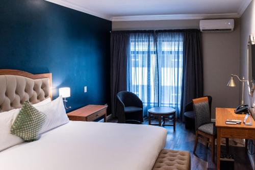 a hotel room with a bed and a desk and a room at Premier Express Inn George in George