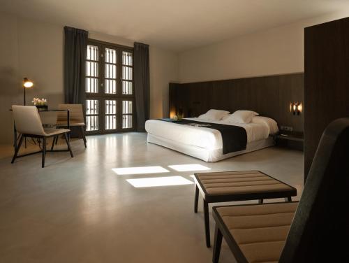 a bedroom with a large bed and a table and chairs at Caro Hotel in Valencia