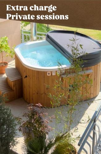 a jacuzzi tub in a garden with a sign that reads extracharge at Boutique Wine and Wellness Retreat - Wine Residence Kerman in Štrigova