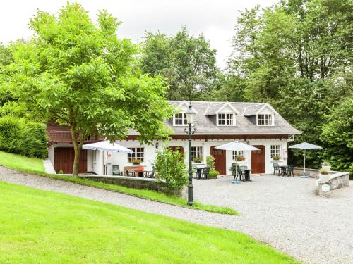 a house with tables and umbrellas in front of it at Cottage Near Durbuy Forest in Barvaux