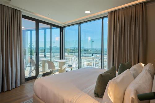 a bedroom with a large bed and a large window at WorldHotels Guadalajara Zona Andares in Guadalajara