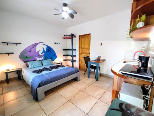 a bedroom with a bed and a desk with a laptop at Casa Ceiba Samara in Sámara