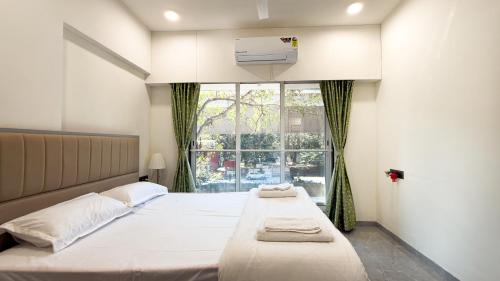 a bedroom with two beds and a window at CozyKey Kalina in Mumbai