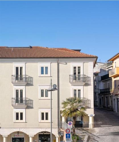 a large white building with balconies on a street at Piazza Duomo Guest House in Ariano Irpino