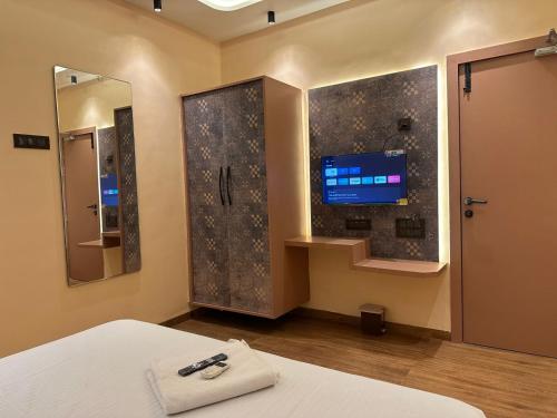 a bedroom with a bed and a tv and a mirror at Hotel Vyankatesh Inn in Nashik