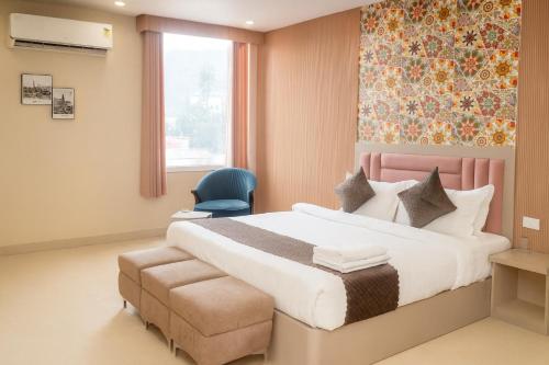 a bedroom with a large bed and a blue chair at Cherrywood at Rajpur Road by Zenvana in Dehradun